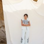 Elegante y fresco conjunto de dos piezas confeccionado en tejido ligero de color blanco, realzado con delicados bordados en azul que aportan un aire artesanal y sofisticado. El top presenta un diseño femenino y favorecedor que combina a la perfección con el pantalón de corte fluido, creando una silueta cómoda y estilizada. El contraste entre el blanco luminoso y los detalles bordados en azul evoca un estilo mediterráneo, ideal para eventos de día, vacaciones, comidas especiales o celebraciones de primavera y verano. Una propuesta versátil y atemporal que destaca por su elegancia natural y sus cuidados acabados.