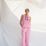 legante y fresco conjunto de dos piezas confeccionado en tejido ligero de color blanco, realzado con delicados bordados en azul que aportan un aire artesanal y sofisticado. El top presenta un diseño femenino y favorecedor que combina a la perfección con el pantalón de corte fluido, creando una silueta cómoda y estilizada. El contraste entre el blanco luminoso y los detalles bordados en azul evoca un estilo mediterráneo, ideal para eventos de día, vacaciones, comidas especiales o celebraciones de primavera y verano. Una propuesta versátil y atemporal que destaca por su elegancia natural y sus cuidados acabados.
